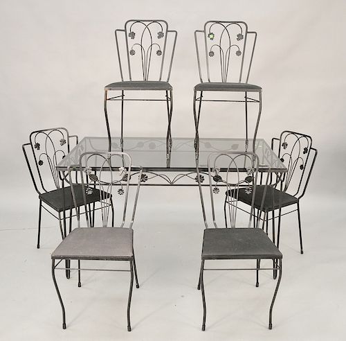 Seven piece iron patio set in the manner of Salterini to include six side chairs and a glass top table (glass most likely replaced)....