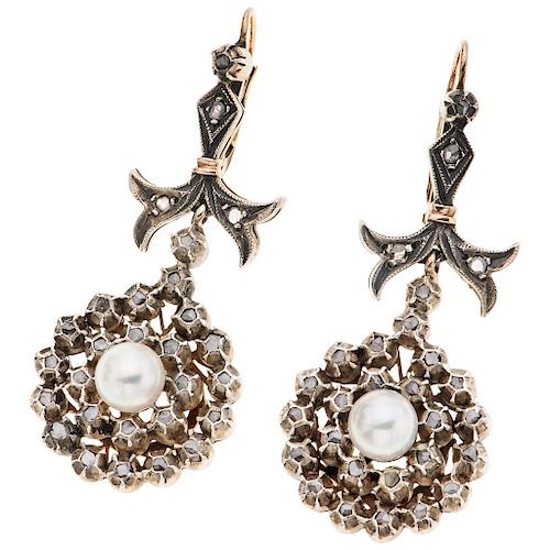 A cultured pearl and diamond 10K yellow gold and silver pair of earrings.