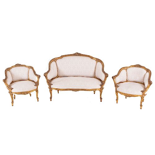 Sala. Siglo XX. Estructura en talla de madera dorada. Consta de: 3 sillones. Con respaldos cerrados y asiento en tapicería color beige.