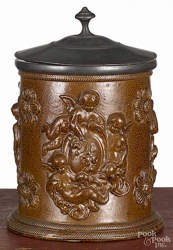 German salt glazed mug, 19th c., with relief cherub and floral decoration and a pewter lid, 7'' h.