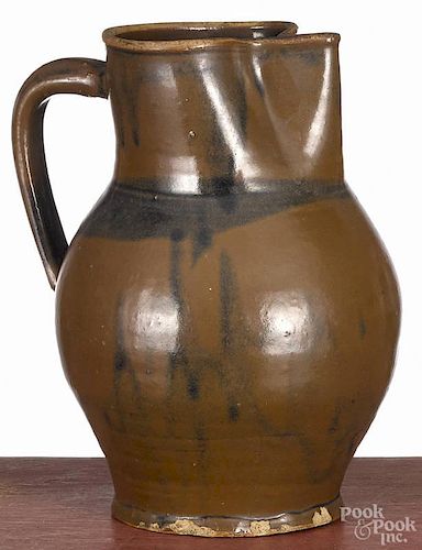 American stoneware pitcher, 19th c., with Albany slip glaze, having an exaggerated pinched spot