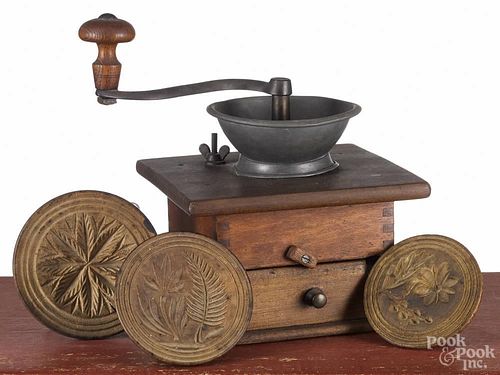 Three carved and turned butter prints, 19th c., largest - 4 1/2'' dia., together with a coffee mill