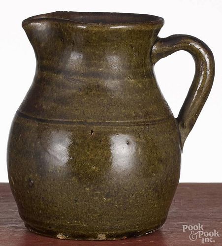 Southern redware pitcher, 19th c., with a green glaze, 6'' h.