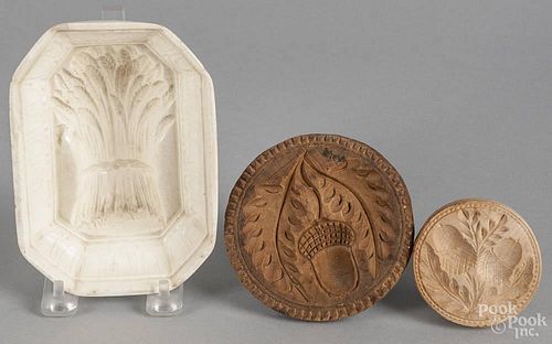 Two carved butter prints, 19th c., with acorn decoration, together with a porcelain sheaf of wheat