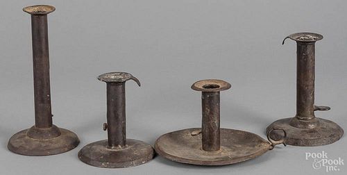 Three iron hogscrapper push-up candlesticks, together with another having a saucer base, 19th c.