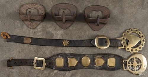 Three heart-formed iron child's stirrups, 3 1/2'' h., together with two horse brasses.