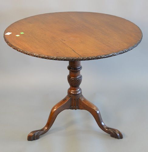 George II mahogany tip table with carved edge and carved feet, 18th century. ht. 27 in., dia 32 1/2 in.