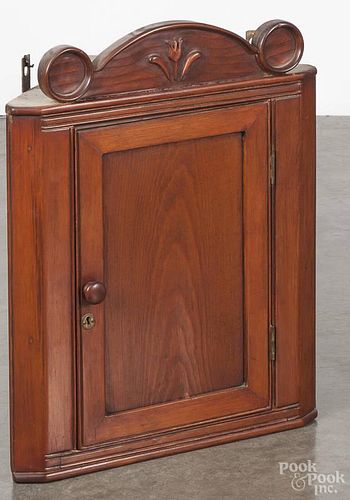 Pine hanging corner cupboard, 19th c., having an arched crest with a carved tulip, 55 1/2'' h., 20'' w