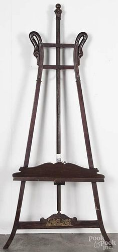 Victorian walnut easel, late 19th c., with carved swan head terminals and an applied brass plaque