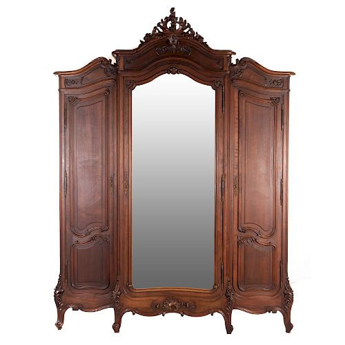 Armario. Francia. SXX. Estilo Luis XV. En talla de madera de nogal. Con 3 puertas abatibles, una con espejo de luna irregular biselada.