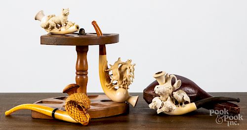 Four carved pipes with stand