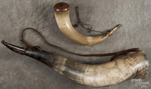 Two powder horns, 19th c., one with a clenched fist finial on the cap, 21 1/2'' l.