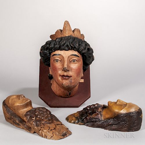 Three Carved and Painted Women's Head Plaques
