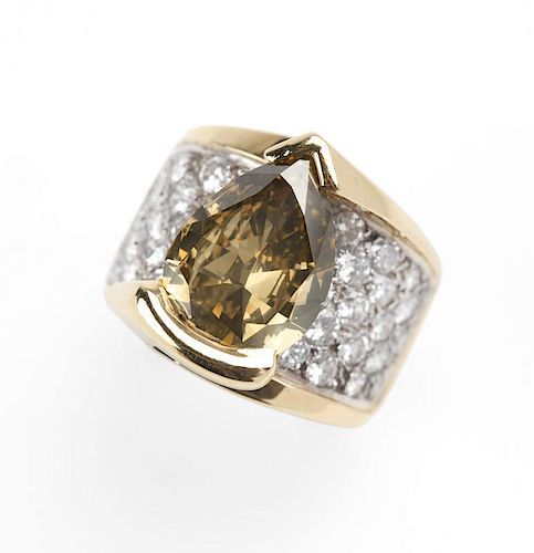 A pear-shaped colored diamond and gold ring