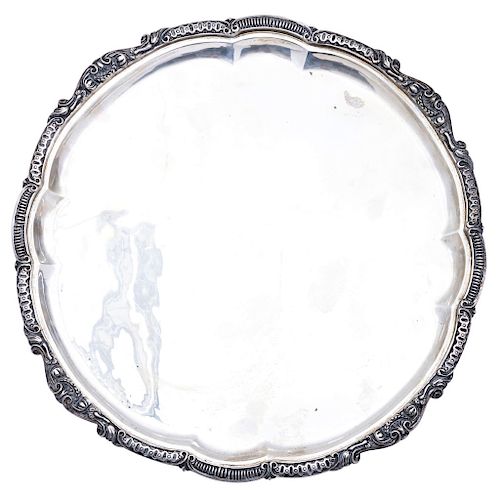 TRAY. MEXICO, 20TH CENTURY. Sterling 0.925 Silver. Brand: SANBORNS. Circular with chased strapwork. The rims embossed with vegetal decoration.