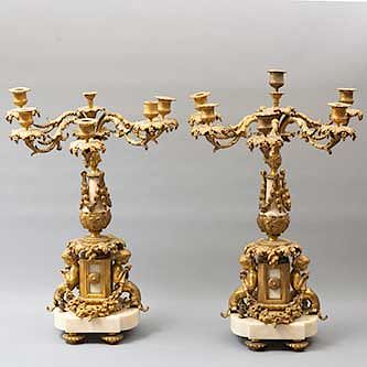 Par de candelabros. Origen europeo. Siglo XX. Elaborados en bronce y mármol beige. Para 6 y 5 luces. Dimensiones: 59 x 37 x 26 cm.