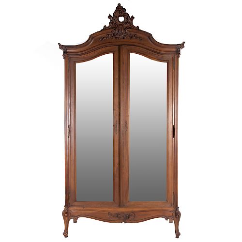 Armario. Francia. SXX. En talla de madera de nogal. 2 puertas abatibles con espejo de luna irregular biselada. 270 x 143 x 52 cm.