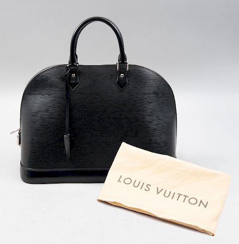 Bolso para dama. Siglo XX. De la marca Louis Vuitton. Elaborada en piel color negro con gofrados orgánicos. Con guardapolvo.