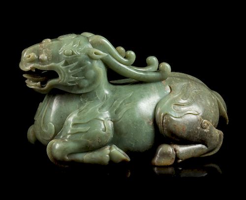 A Celadon Jade Figure of a Recumbent Qilin
Height 11 in., 28 cm. 