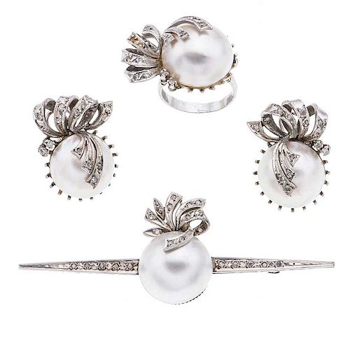Anillo, par de aretes y prendedor con medias perlas y diamantes en plata paladio. 4 medias perlas color blanco de 17 mm. 66 diam...