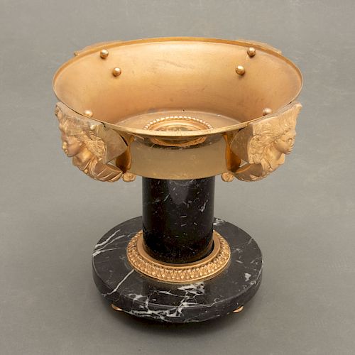 Centro. Estilo imperio. Francia, Siglo XX. Base de mármol y aplicaciones en bronce con medallón y mascarones.