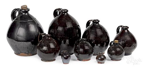 Nine graduated redware manganese glaze ovoid jugs