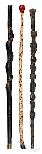 Three carved and painted walking sticks