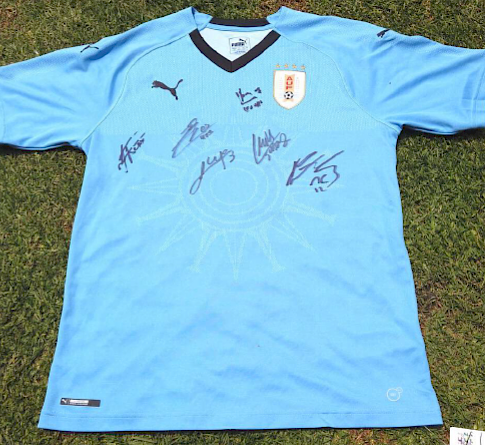 Camiseta de Uruguay firmada por la selección 2018 – incluye firmas de Luis Suárez, Edson Cavanni, Diego Godín y varios más.