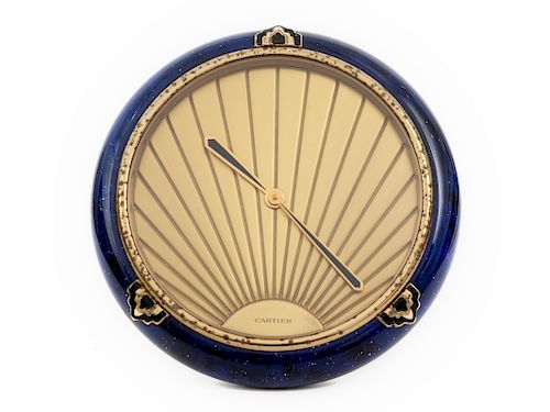 A Cartier Art Deco Style Desk Clock
20TH CENTURY
having a circular brass case decorated with blue lapis lazuli colored enamel; Swiss made Quartz movem