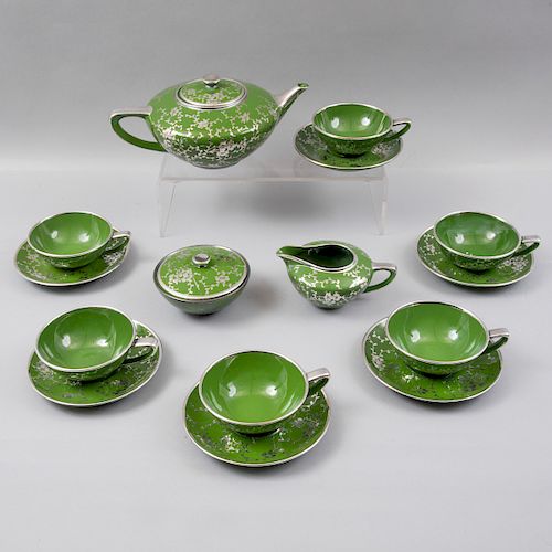 Juego de té. Siglo XX. Elaborado en porcelana verde acabado brillante con cenefa orgánica y filos en esmalte de plata. Pz:15