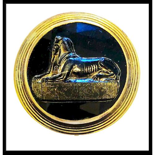 A FACETED AND GLUED SPHINX OVER BLACK GLASS BUTTON