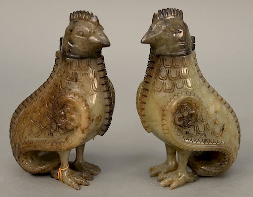 A pair of celadon and russet jade archaistic bird, from vessels with covers, carved as standing birds with detachable heads, 19th/20th century. height