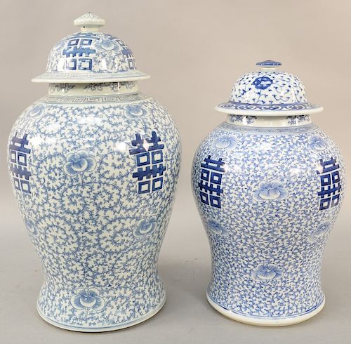 Two similar Chinese porcelain jars, both with covers in baluster form with scrolling vines and lotus flower blue decoration. heights 17 inches and 20 