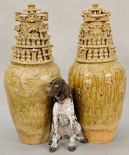 Pair of massive song-style stoneware funerary urns, China, 20th century, decorated with multiple tiers of figures and pavilions. height 40 inches.