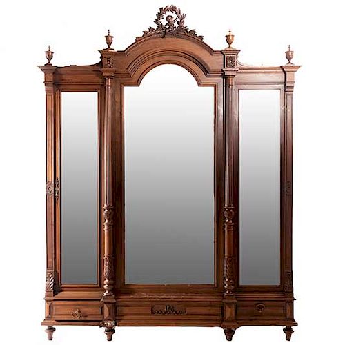 Armario. Francia. SXX. En talla de madera de nogal. Con 3 puertas con espejos de luna biselada y 2 cajones. 242 x 185 x 55 cm.