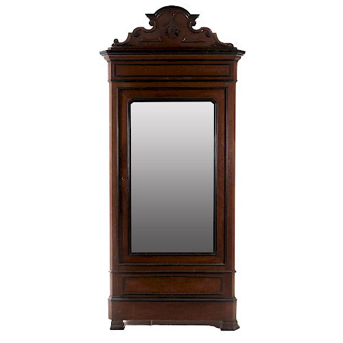 Armario. Siglo XX. En talla de madera. Puerta abatile con espejo de luna irregular y cajón. 242 x 116 x 50 cm.