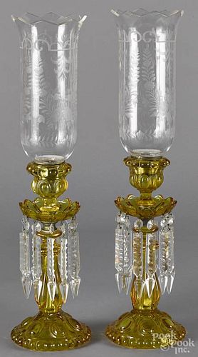 Pair of yellow Vaseline glass candlesticks, early 20th c., with hanging crystal decoration