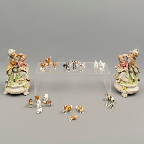 Lote de 26 piezas. Japón. SXX. Elaboradas en porcelana. Acabado gres. Consta de: 2 parejas de niños, 15 perros miniatura, otros.