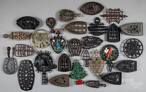 Collection of twenty-eight cast iron trivets