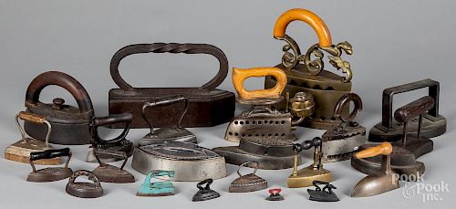 Collection of twenty-three cast iron sad irons
