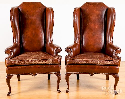 Pair of leather upholstered wing chairs.