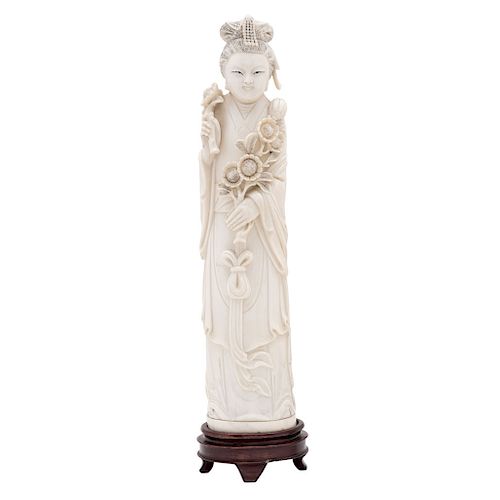 LADY WITH FLOWERS. CHINA, EARLY 20TH CENTURY. Carved ivory with black ink details. 13 in tall.