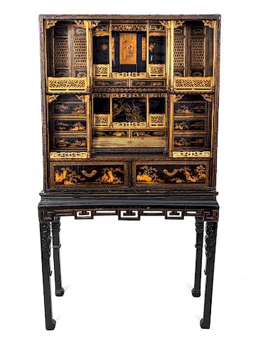 A Chinese Export Gilt Decorated Black Lacquered Cabinet-on-Stand
Height 72 x width 38 1/2 x depth 19 inches.