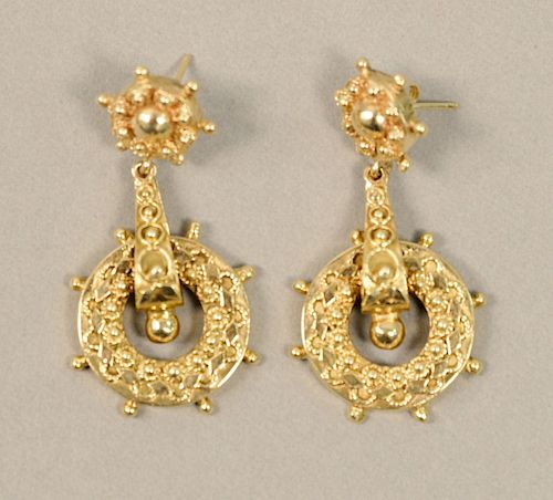 Pair of 14K gold pierced earrings with ships wheel design, 13 grams.