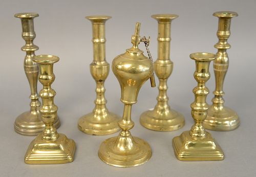 Seven piece brass group to include two pairs of push up candlesticks, an oil lamp and a pair of heavy brass candlesticks. ht. 7 1/2 in to 11 1/4 in. P