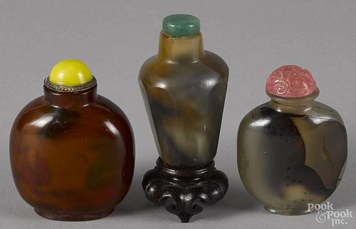 Three Chinese carved hardstone snuff bottles, one with a reverse painted scene.
