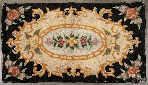 American hooked rug, early 20th c., in a floral pattern, 34'' x 57''.