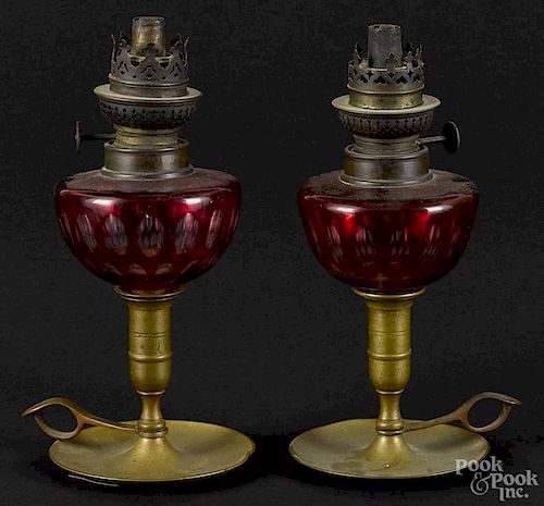 Pair of brass fluid lamps, 19th c., with cranberry cut to clear fonts, 9 1/4'' h.