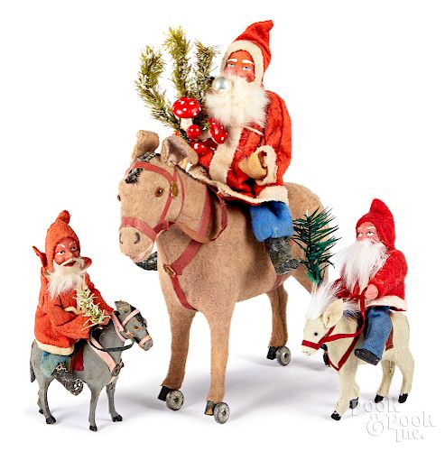 Three composition Santa Claus figures on donkeys