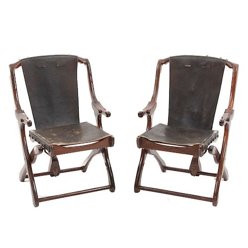 Par de sillas "Sling". MŽxico. A–os 70. Dise–o Don S. Shoemaker. En talla de madera tropical. Con respaldo y asiento en piel negra.